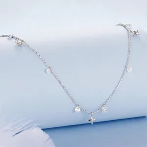 S925 sterling silver necklace with star charms and cubic zirconia tassels over blue background