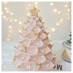 Detailed close-up of pink Christmas tree music box with golden star and bow accents