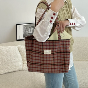 Detail of vintage plaid wool tote bag showing the textured fabric and brand label