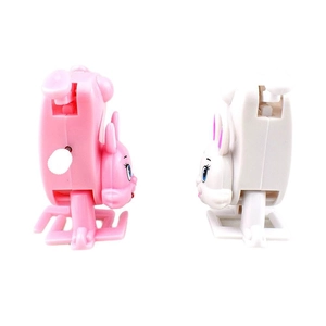 Pink and white wind-up bunny toys walking upside down on a clean white background