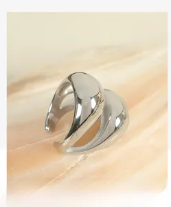 Close-up of polished silver chunky ring with a liquid metal aesthetic on stone surface