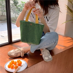 Detailed shot of houndstooth wool tote bag with vibrant yellow straps and snap closure