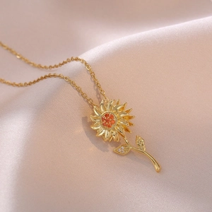 Collier tournesol doré avec cristaux orange sur un tissu en soie pêche douce