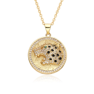 Macro shot of gold leopard pendant with black enamel, green eye and cubic zirconia detail