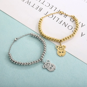 Macro view of gold and silver beaded bracelets with hollow pig charms on artistic card