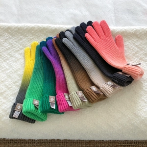 Close-up of colorful rib-knit cuffs with small labels on soft knitted gloves