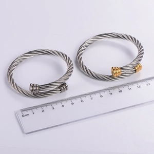 Detail view of woven steel cable bangles with measurements in silver and gold-tone finish