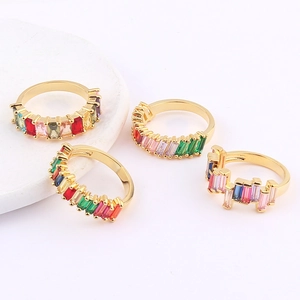 Macro shot of gold-plated rings featuring colorful baguette-cut crystals in a set