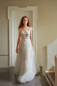 Détail d'appliqués papillon 3D sur une robe de mariée blanche en tulle multicouche