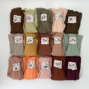 Flat lay of pleated cotton viscose shawls in multiple colors with numbered labels