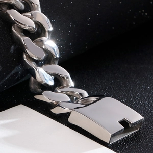 Macro view of a silver polished stainless steel Cuban link chain with a square clasp