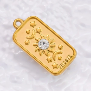 Detail of 18K gold tarot pendant with sun, moon, stars and zircon inlay