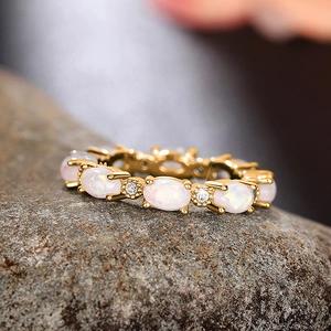 Vue macro d'une bague d'éternité dorée avec opales blanches et pierres de zircon