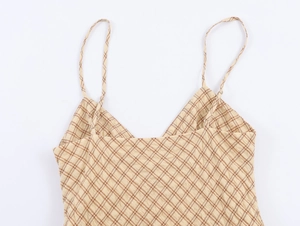 Détails du motif à carreaux et du décolleté à lacets sur la robe caraco beige
