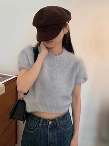 Close-up of a grey short-sleeve mohair knit sweater with soft fuzzy texture on a model