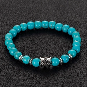Close-up of blue striped agate beads and vintage silver owl pendant on bohemian bracelet