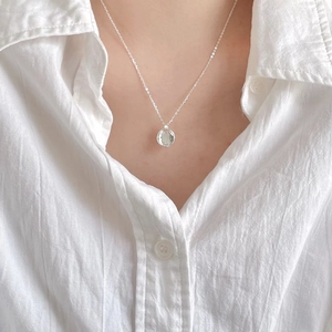 Macro view of minimalist 925 sterling silver necklace with oval rainbow crystal pendant