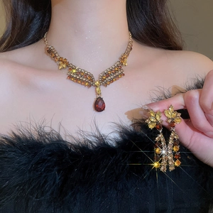 Detail of French vintage floral jewelry set with amber stones and red pendants on model