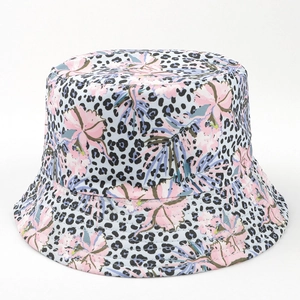 Détail du chapeau bob bleu clair avec motifs de fleurs tropicales roses et imprimé léopard
