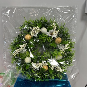 Detailed view of Easter wreath with speckled eggs and white berries in protective wrap