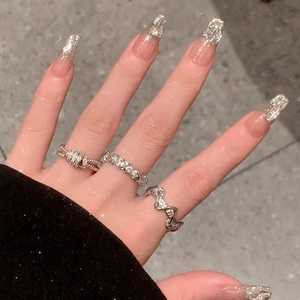 Macro detail of three silver geometric rings with zircons on a hand model