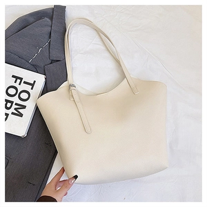 Vista dettagliata della borsa tote bianco sporco che mostra la trama della pelle martellata