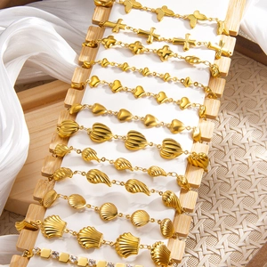Detailed collection of 18k gold plated bracelets with shell and cross charms on wood display