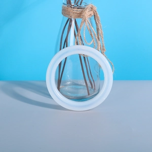 Detail of a wide translucent silicone bangle mold standing vertically on a gray surface