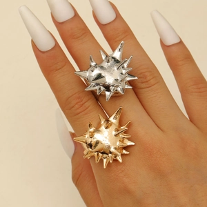Detailed view of punk urchin rings in silver and gold plating worn on hands