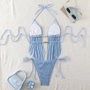 Detail of light blue halter swimsuit with textured fabric and wooden ring ornaments