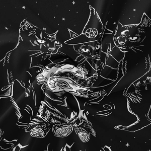 Detail of black cat tapestry fabric showing white line art of mystical wizard cats
