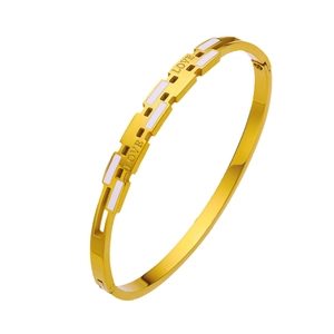 Polished gold titanium bangle with white enamel inlay and engraved LOVE lettering