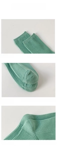 Detail view of mint green knit socks showing elastic cuffs and reinforced toe and heel