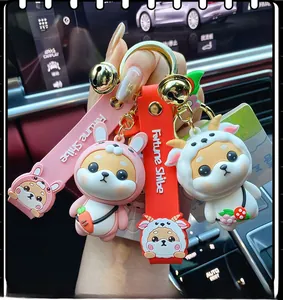 Close-up of Shiba Inu keychain set in pink rabbit and white goat outfits with bells