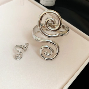 Detailed close-up of a silver spiral ring and open bangle set in a luxury jewelry box