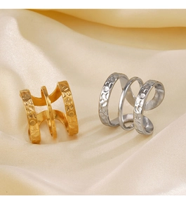 Close-up of gold and silver triple-layered ear cuffs with hammered and smooth texture details
