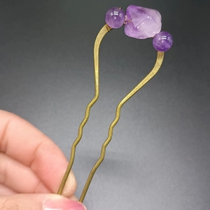 Detail of vintage bronze U-shaped hair pin with raw purple amethyst and gemstone beads