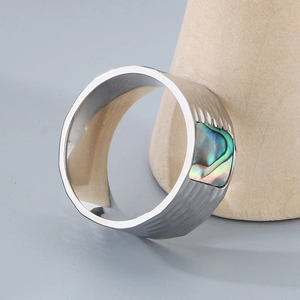 Detailed close-up of a silver stainless steel ring with colorful abalone shell inlay