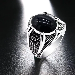 Detailed close-up of a vintage silver men ring with oval black obsidian gemstone