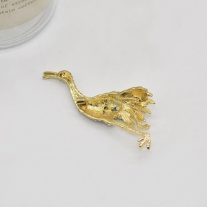 Elegant gold crane bird brooch with rhinestones showing professional metal back detail