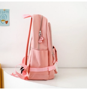 Detailed side view of pink nylon backpack showing zipper layers and side pockets