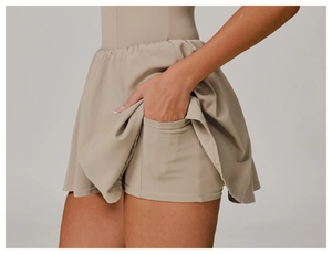 Détail d'une jupe-short de sport beige avec taille haute et poche latérale pour téléphone