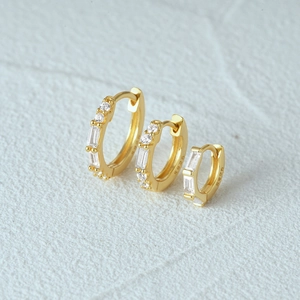 Detailed view of three gold S925 silver hoop earrings with white zircon in various sizes