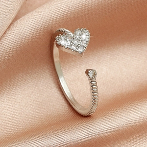 Macro detail of silver heart ring with pavé crystals and spiral rope band texture