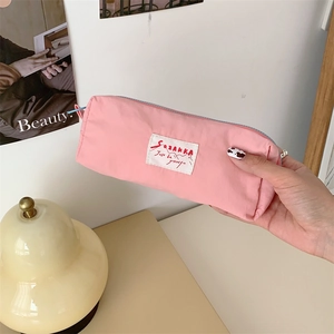 Pink macaron fabric pencil case with white label and zipper for stationery storage