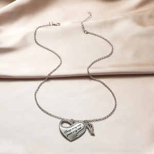 Detailed view of silver heart pendant with angel wings and engraved emotional quote