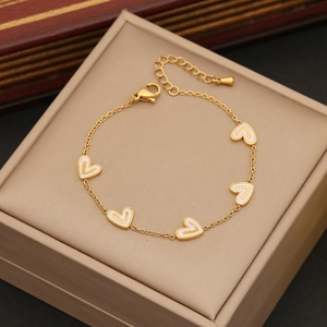 Collier en acier inoxydable doré avec cinq cœurs blancs dans une boîte cadeau beige