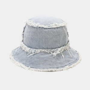 Detail view of frayed edges and twill texture on a washed denim reversible bucket hat