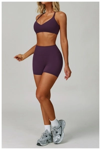 Detailed full body view of purple yoga set with V-neck sports bra and high-waist biker shorts