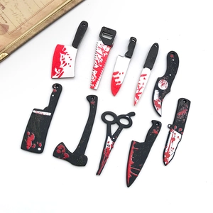 Detailed view of bloody acrylic miniature knives and saws for Halloween DIY jewelry making